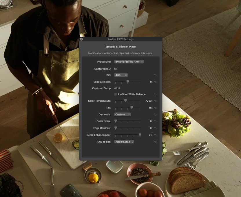 iPhone 17 Pro screen showing pro workflows for video, a person stands at a kitchen counter and chops vegetables
